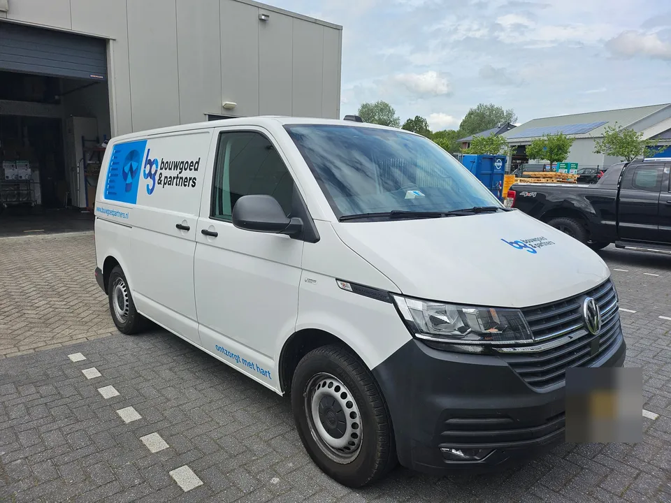 Witte bedrijfsbus met belettering, voorzijde