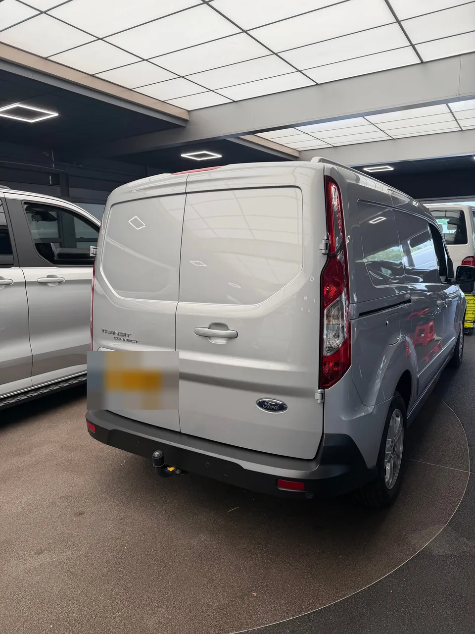 Zilvergrijze Ford bestelwagen van achteren, zonder striping