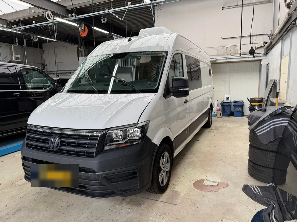 Camper vóór het wrappen: wit voertuig met grijze onderzijde in de werkplaats
