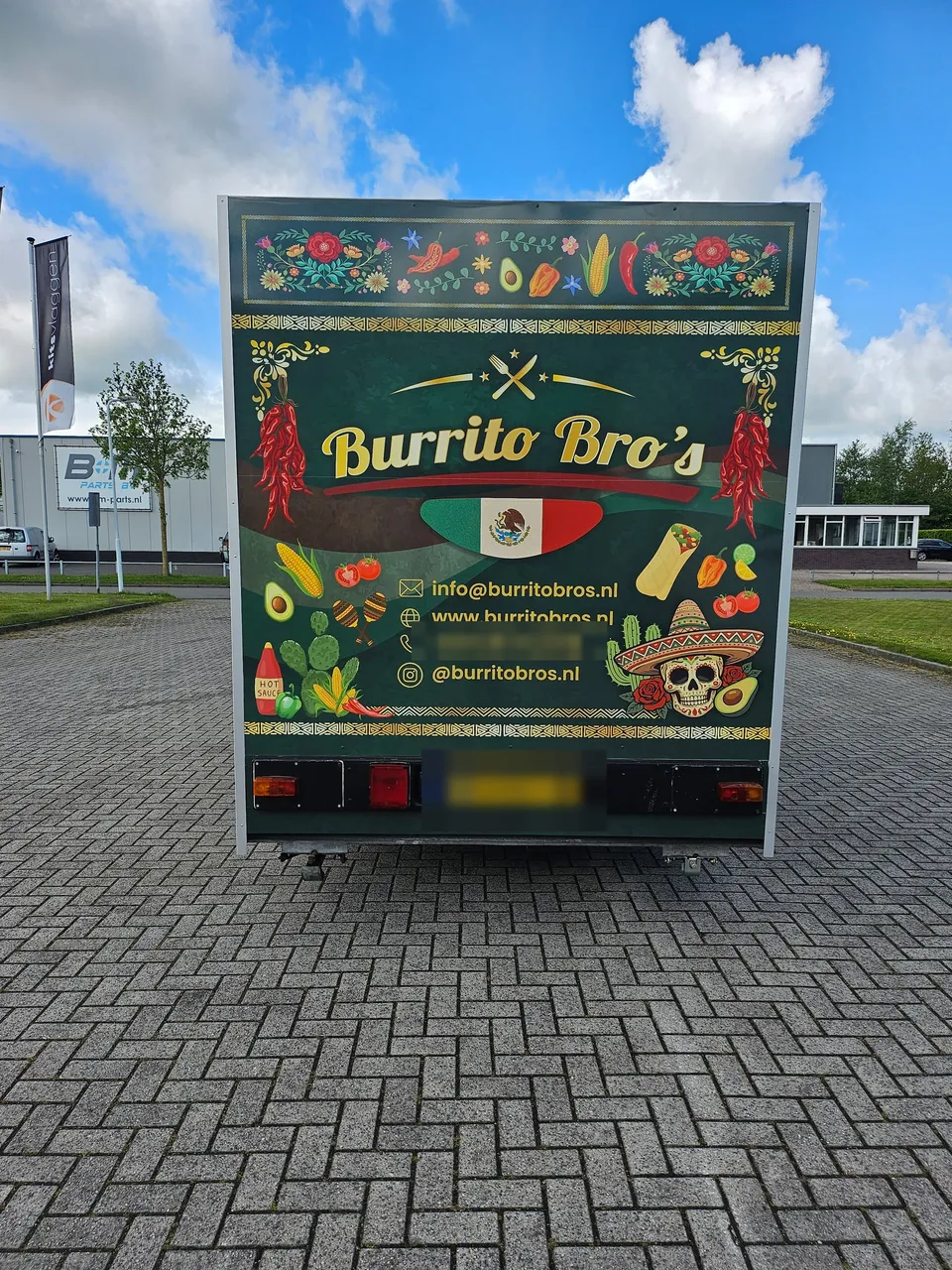 Achterzijde van de foodtruckaanhanger met reclame