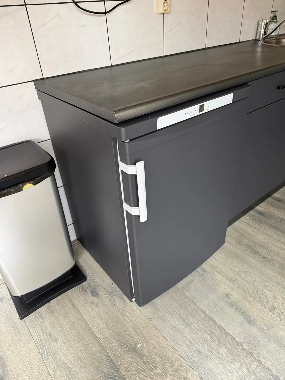 Keuken na het wrappen: detail van antracietkleurig kastje