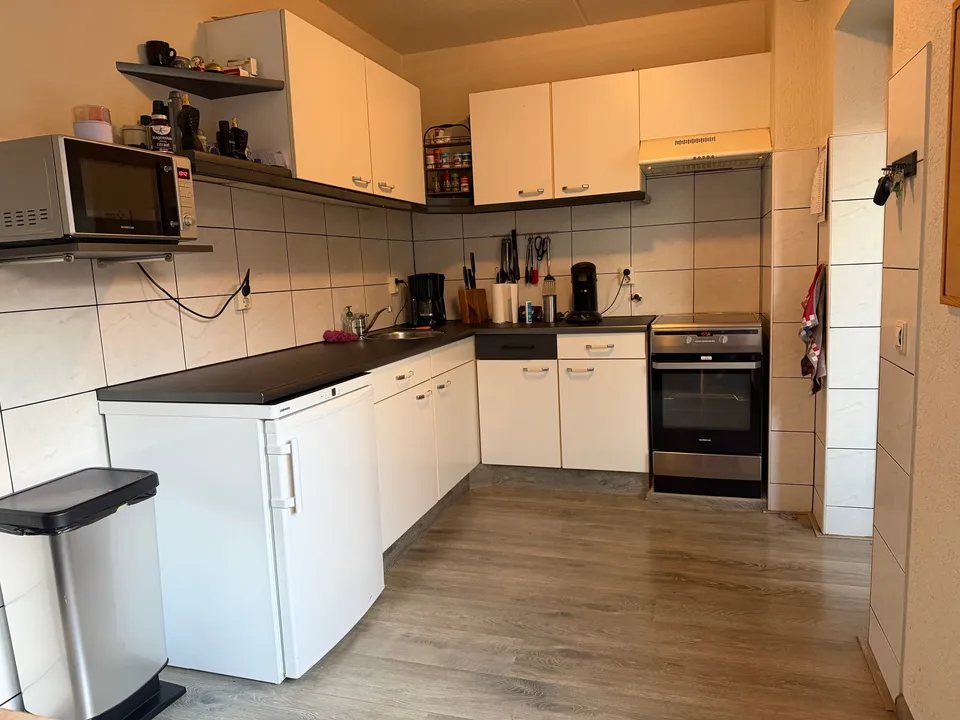 Keuken vóór het wrappen: witte keukenkastjes, met tegelwand op de achtergrond