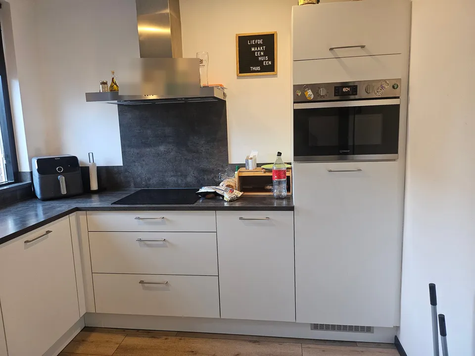 Keuken vóór het wrappen: witte keukenhoek met afzuigkap