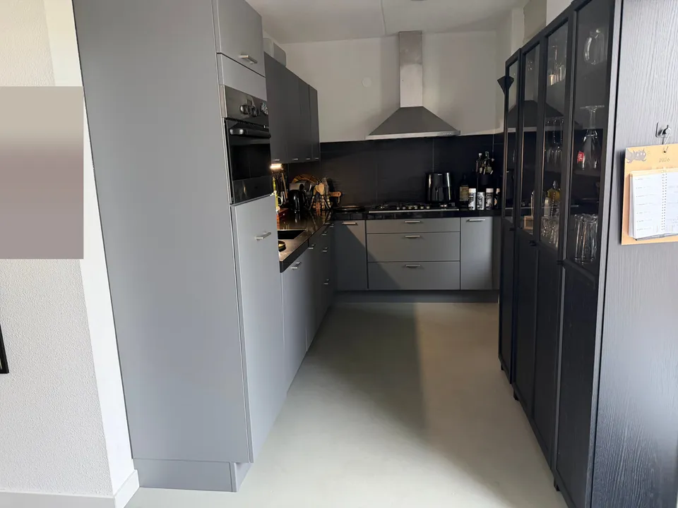 Keuken na het wrappen: grijze keuken, met een zwarte kast in beeld