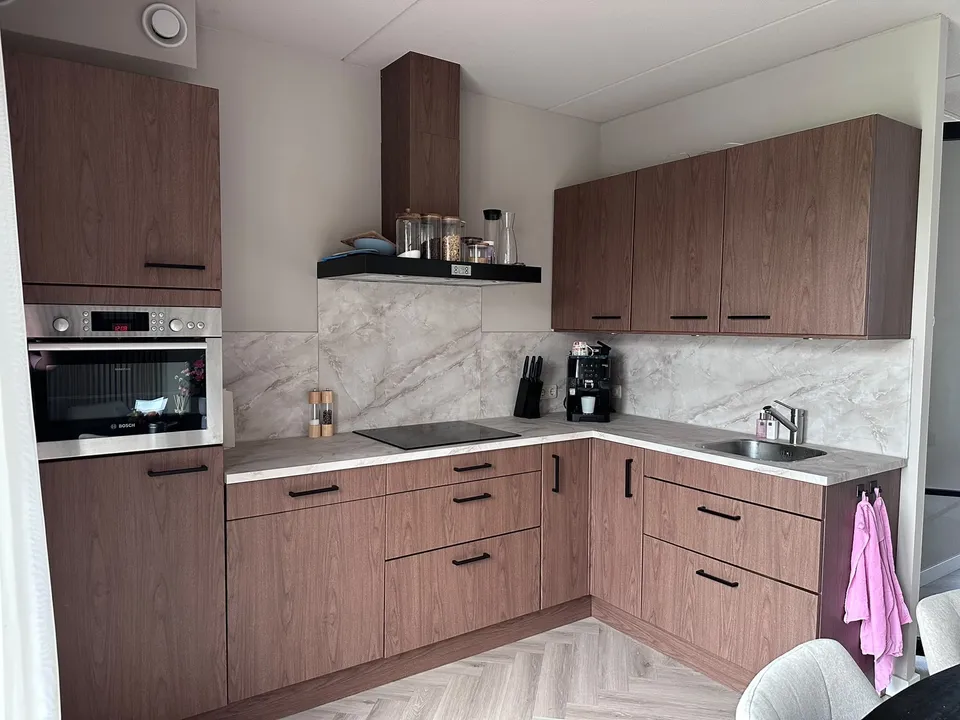 Keuken na het wrappen: keukenhoek met inbouwmagnetron en houtlook