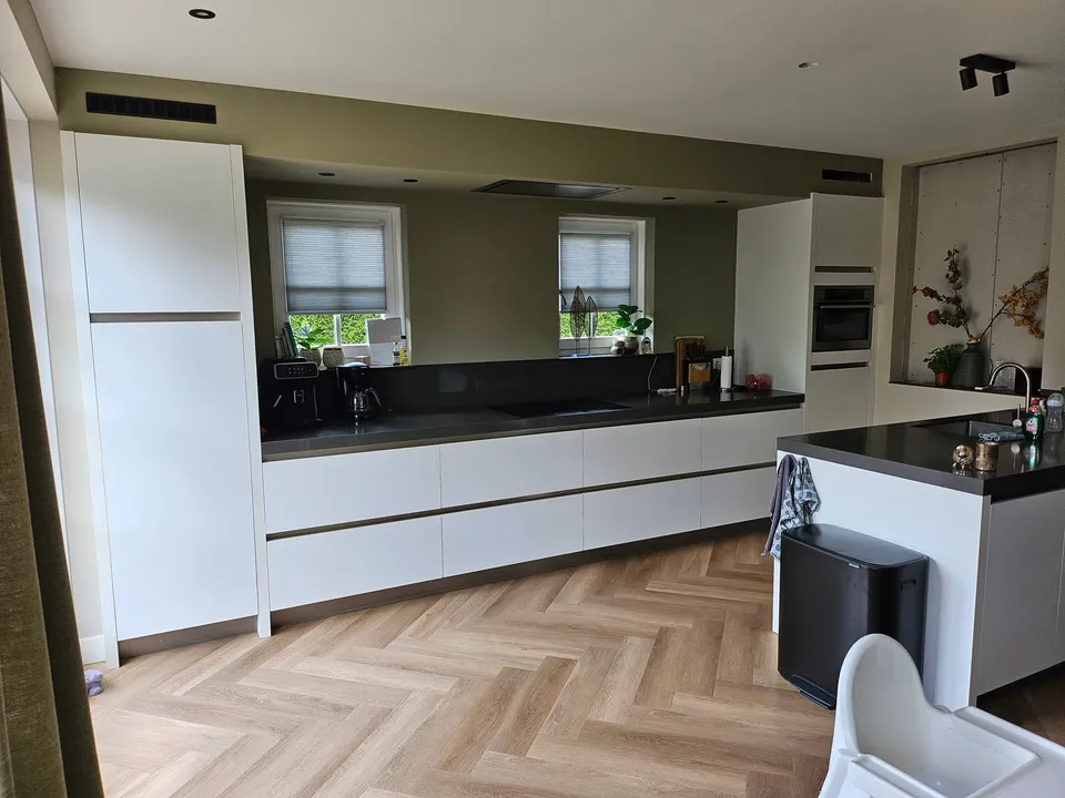 Keuken vóór het wrappen: witte keukenwand en eiland