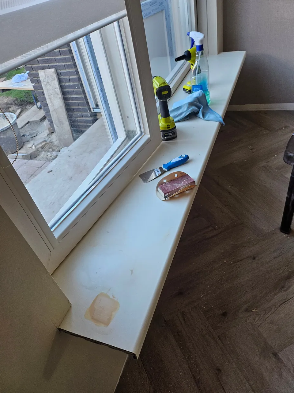 Vensterbank vóór het wrappen: beschadigd en verkleurd blad met gereedschap