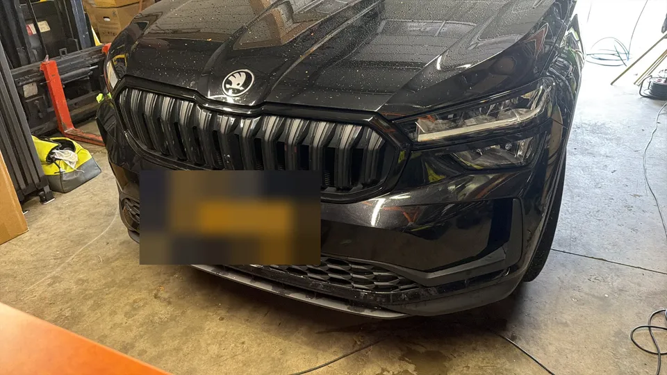 Zwarte voorgrille van een auto na het ontchromen
